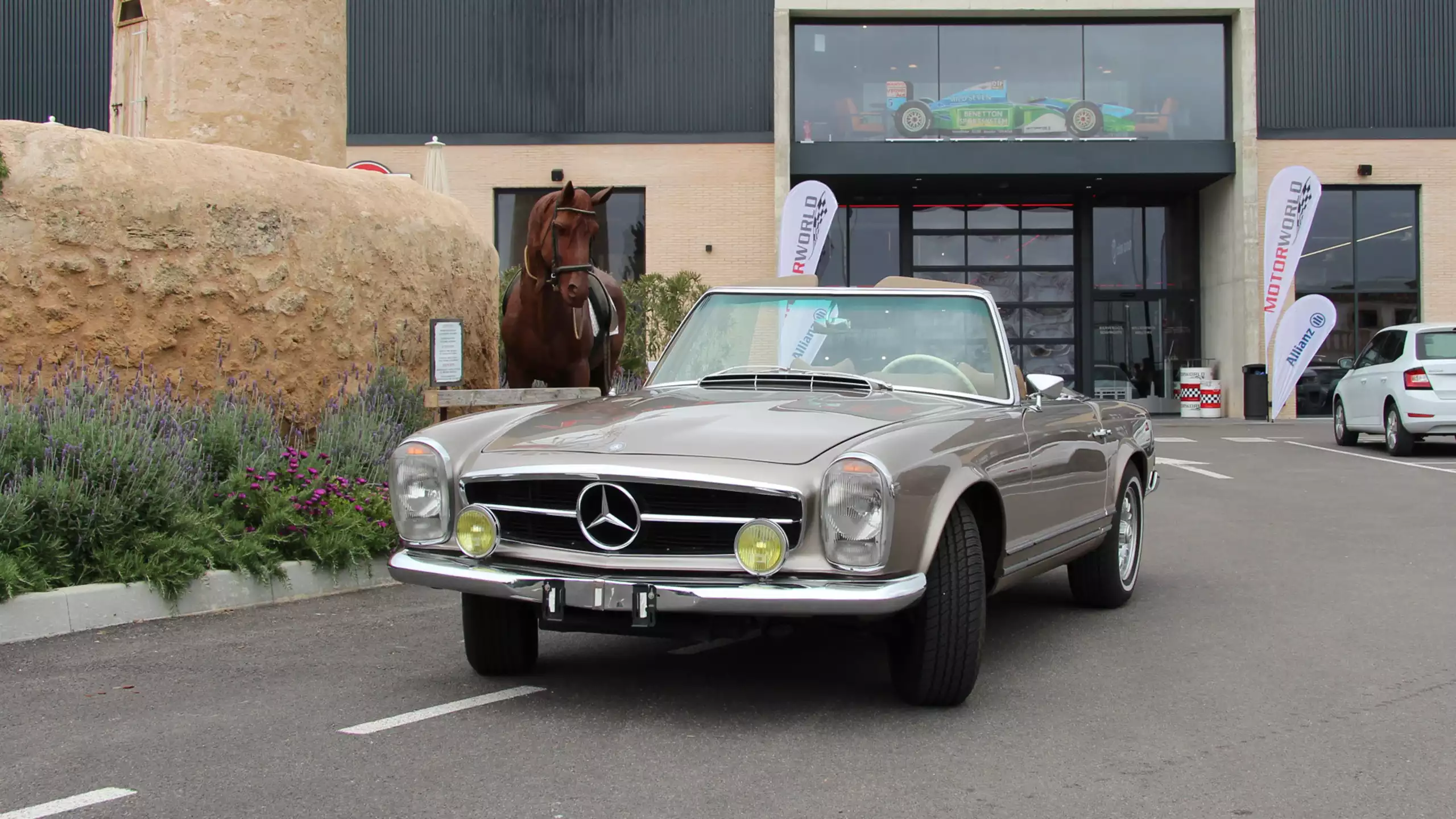 Silberner Oldtimer vor Gebäude